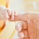 Bébé tenant la main d’un adulte – congé supplémentaire de naissance