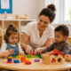Professionnelle de crèche accompagnant de jeunes enfants lors d’une activité