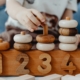 jeune enfant manipulant des anneaux en bois lors d’une activité d’éveil accompagné de professionnels petit enfance